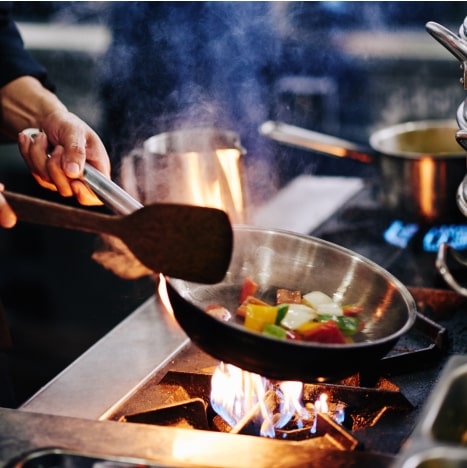 Chef frying vegetables on pan