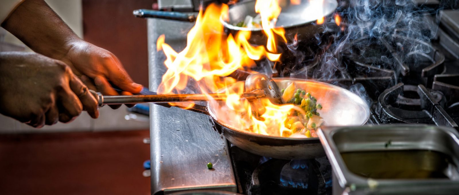 Culinary Solutions - Chef Frying Food In Flaming Pan On Gas